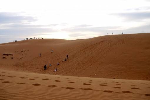 Sand boarders and sunset seekers on the Red Sand Dunes Mui Ne