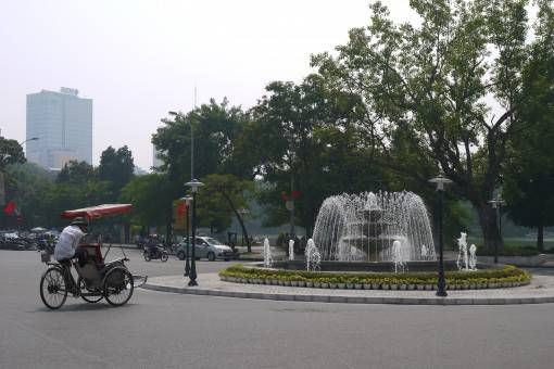Cyclo driver and fountain in Hanoi's Old Quarter