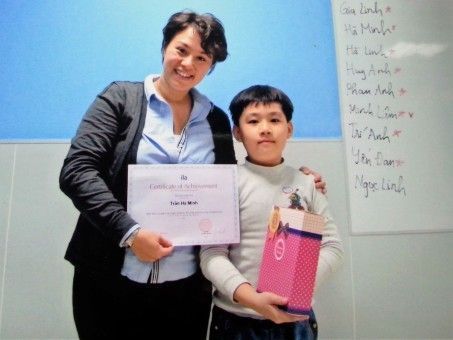 Melissa giving a prize to a Vietnamese student
