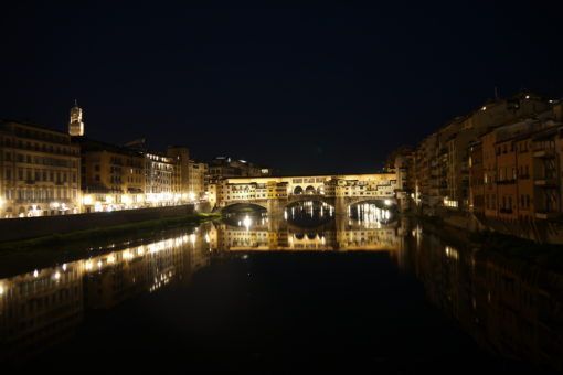 Ponte Vecchio at night, lights reflecting off the Arno river
