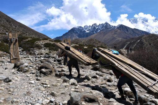 Porters carrying timber up the Everest Base Camp trail in Nepal