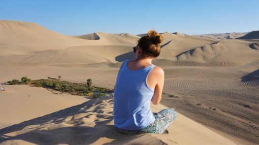 Looking at the view of Desert sand dunes in Huacachina, Peru