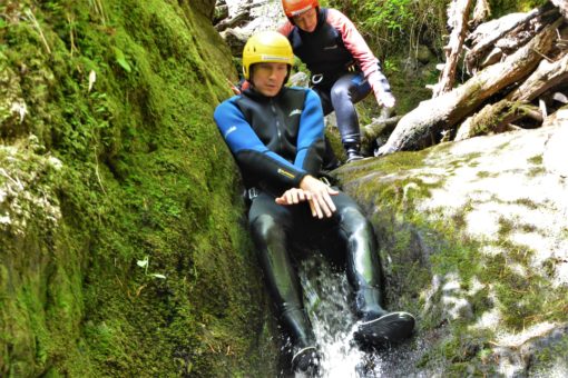 Andrew sliding down rocks on a canyoning trip in Scotland with ACE Adventures