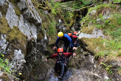 Scrambling along the river on a canyoning trip in Scotland