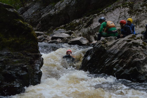 Sliding down a rapid on the Findhorn River in Scotland on a rafting trip with ACE Adventures