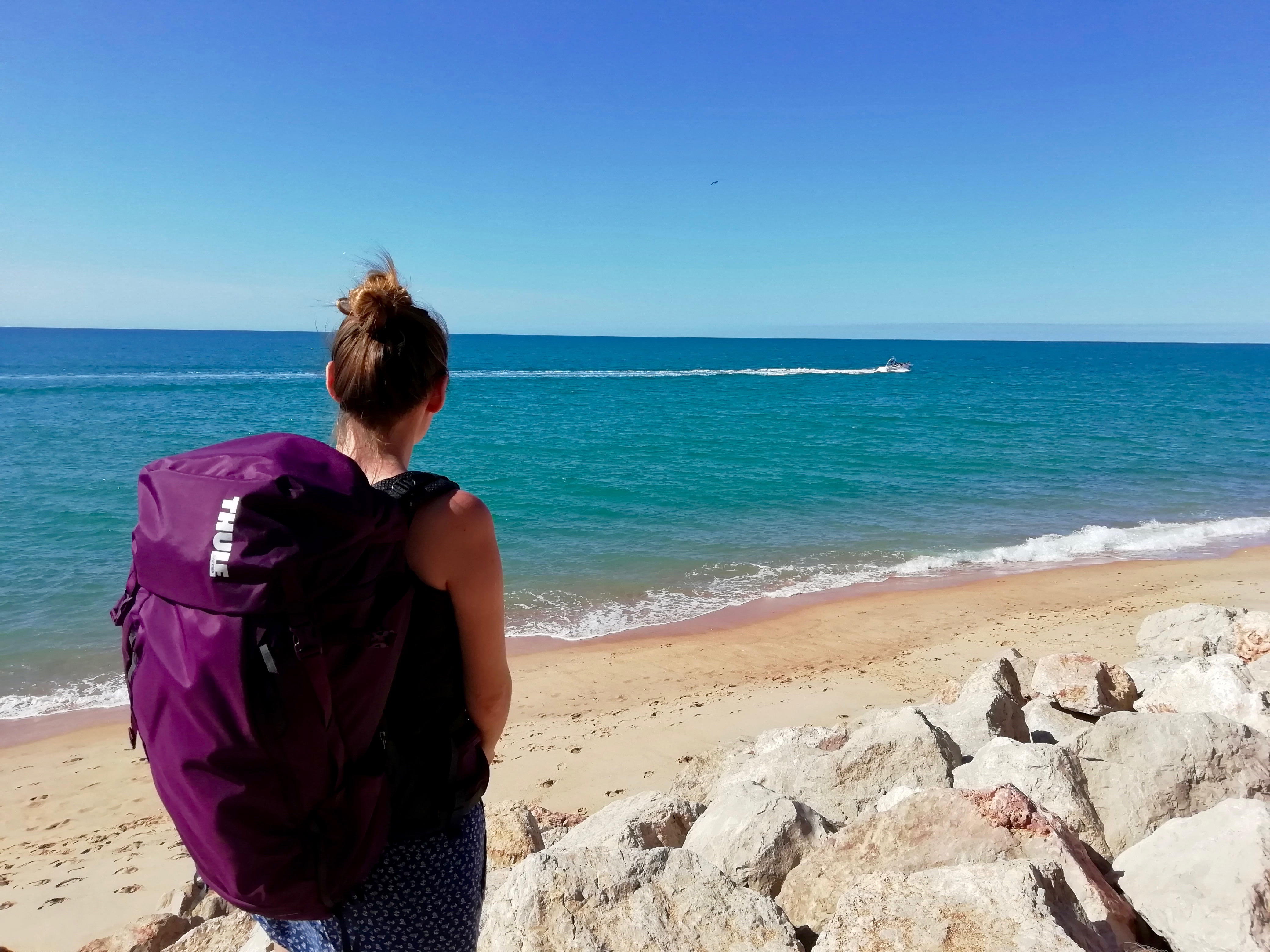 Amy carrying the 35L Thule AllTrail backpack by the sea