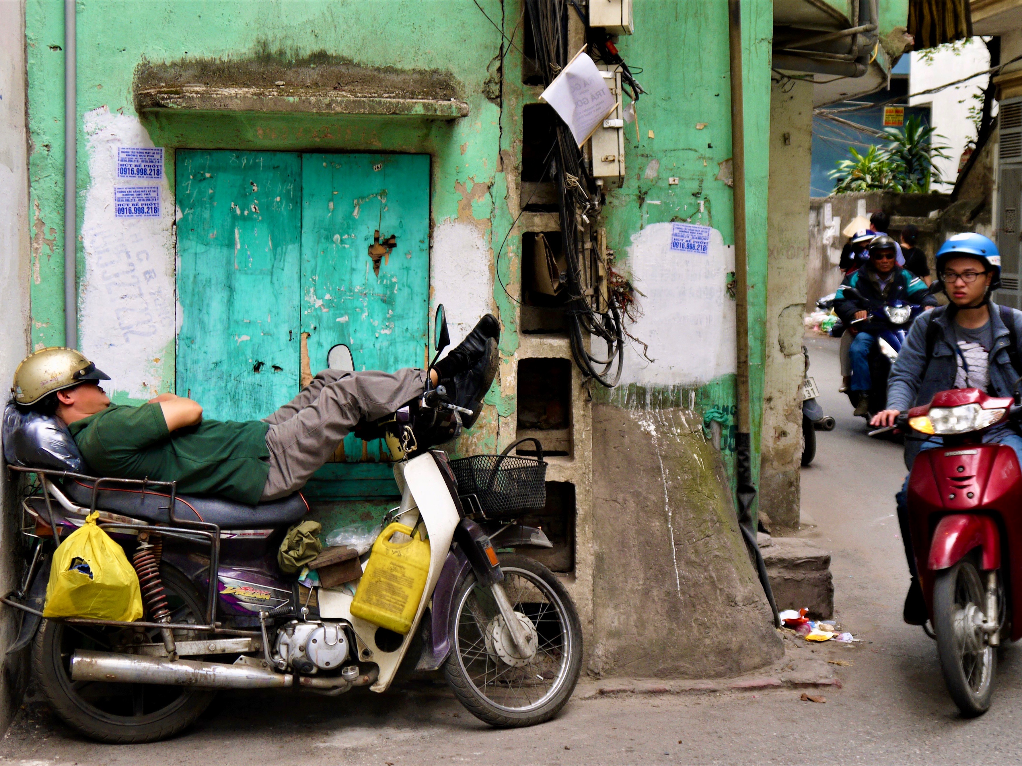 Man sleeping on motorbike in Hanoi