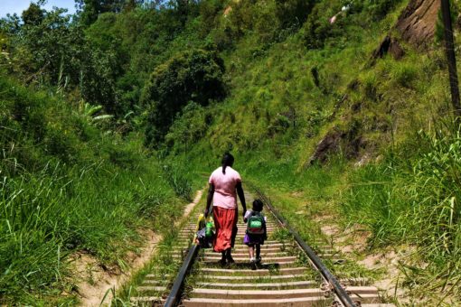 Woman and child walking down railway tracks in Ella, Sri Lanka