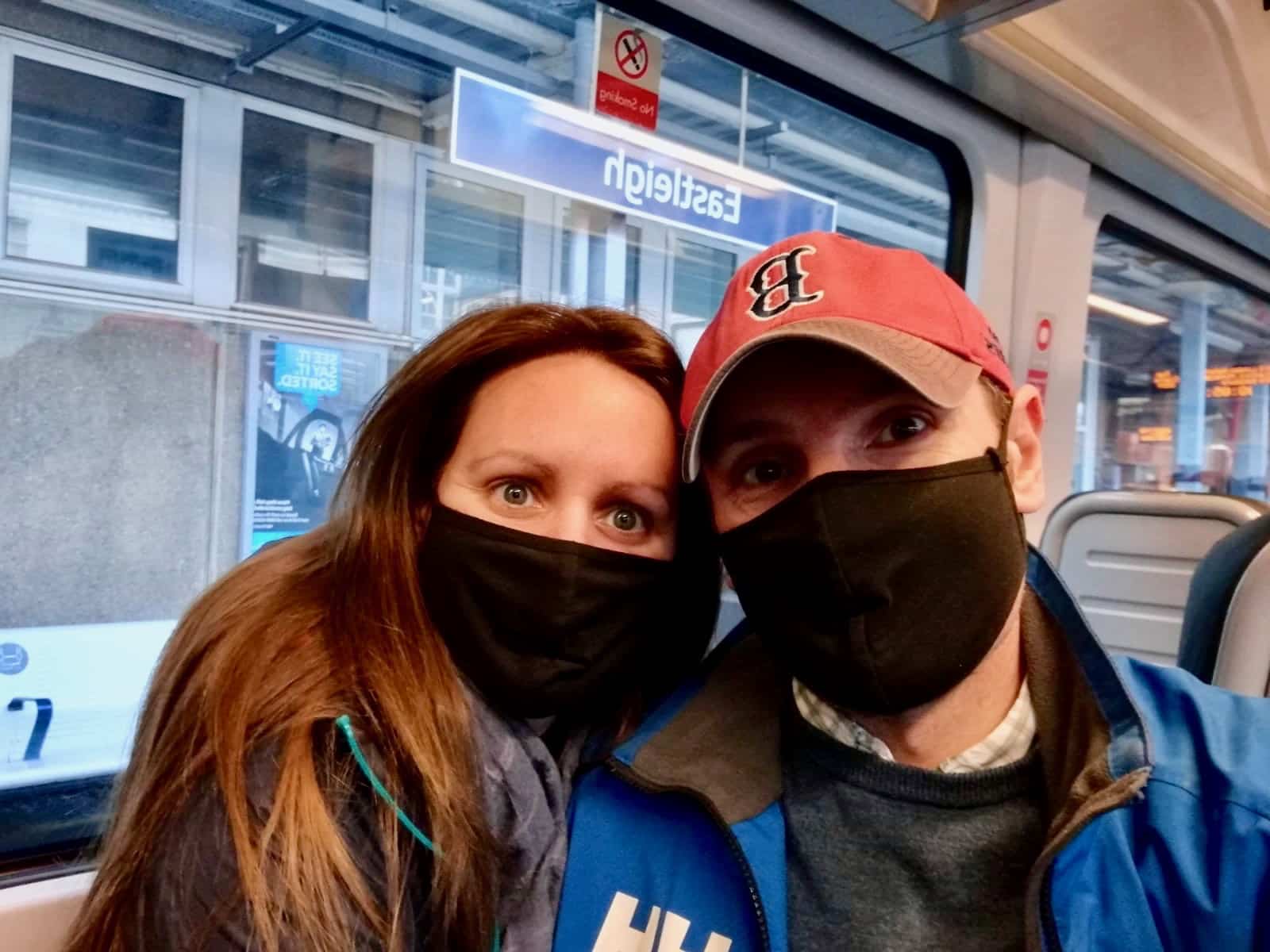 Us with Covid masks on the train to the airport