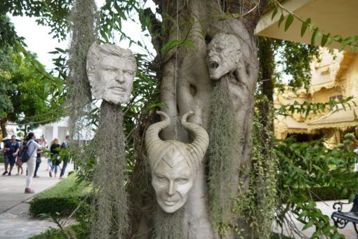 Heads of move characters hanging from trees at the White Temple in Thailand