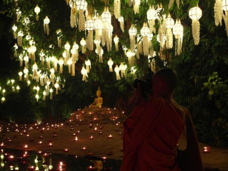 Monk taking photos of a lantern display at Wat Phan Tao during Yi Peng, Chiang Mai