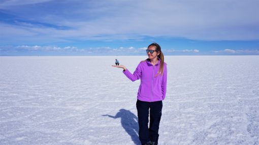 Salt flats perspective photo - big person holding a small one on the palm of their hand