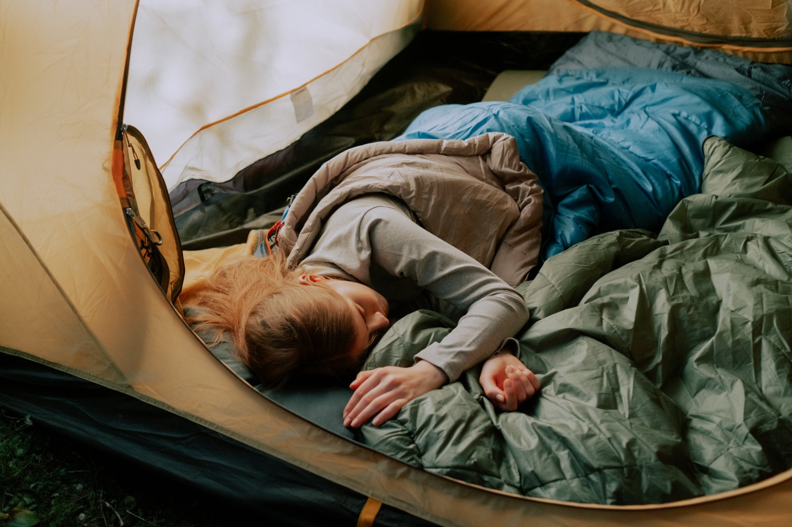 Woman sleeping in a sleeping bag in a tent