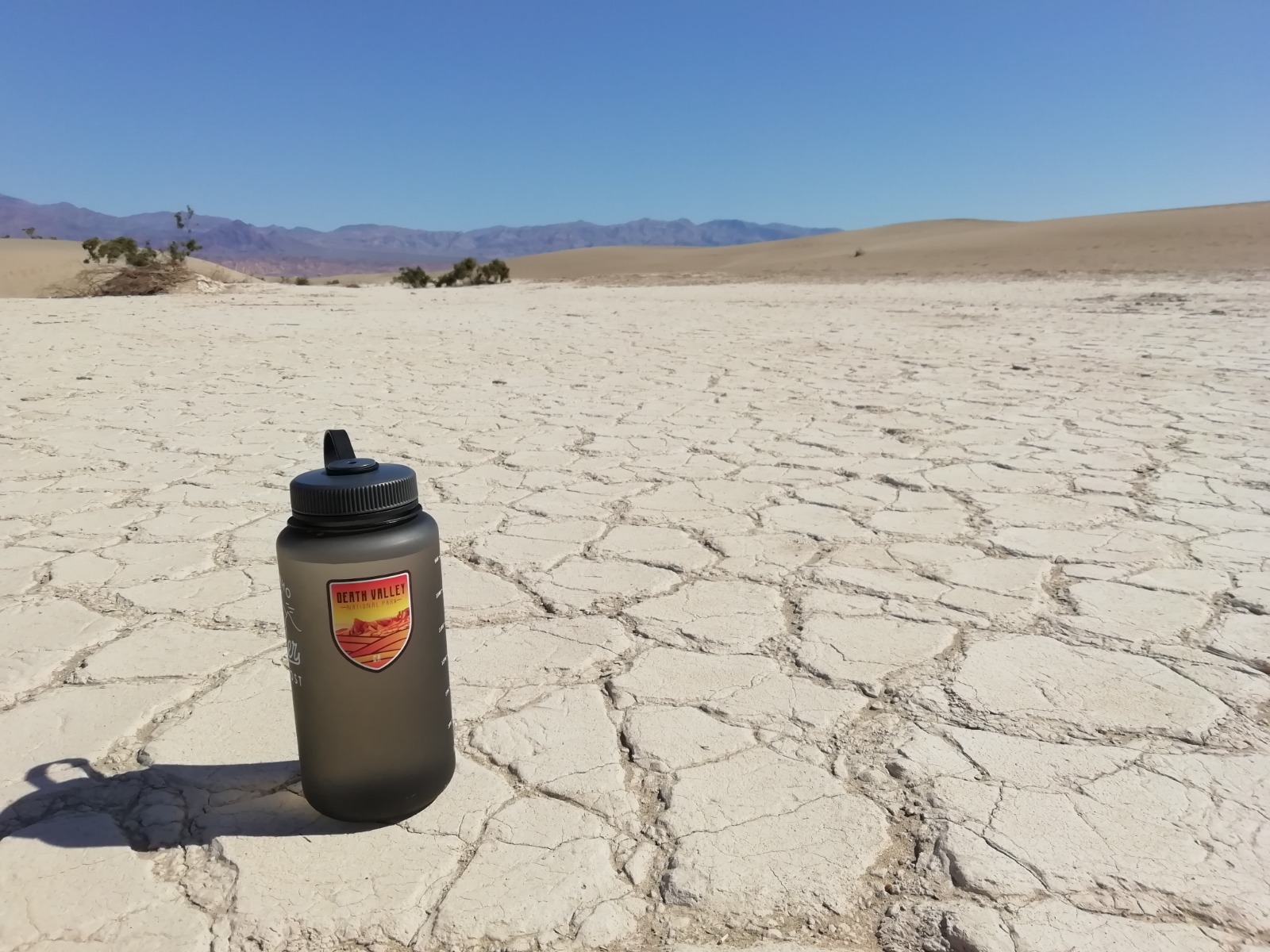 Water bottle on a cracked, dry desert floor
