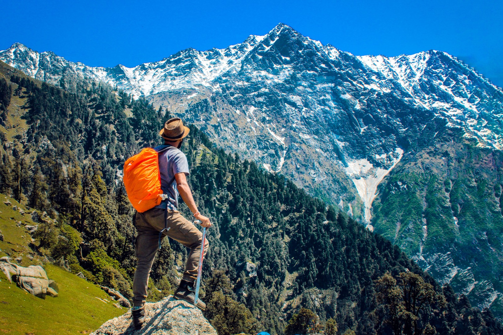Man hiking in the wilderness with a backpack looking at the mountains